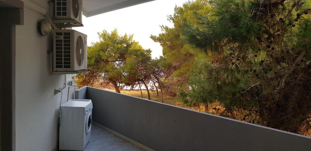 einen weißen Kühlschrank an der Seite einer Wand mit Bäumen in der Unterkunft Appartamenti Rivabella Gallipoli in Rivabella