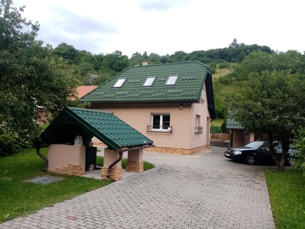 een huis met een groen dak en een oprit bij Apartmán Starý Mlyn in Kremnica