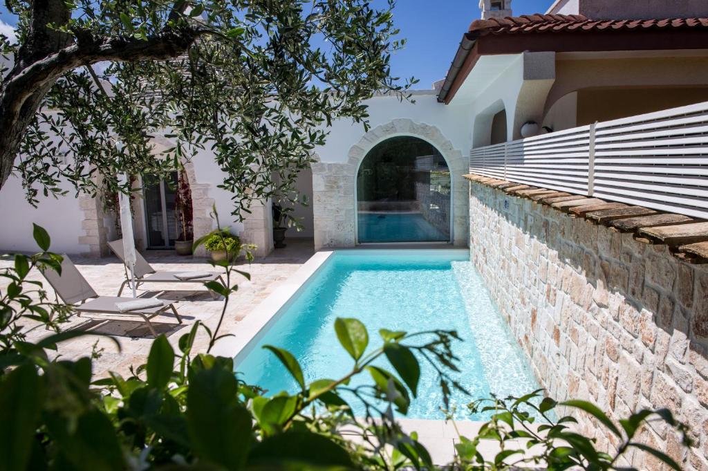 a swimming pool in the backyard of a house at Trulli Pietraviva with Pool in Santa Lucia