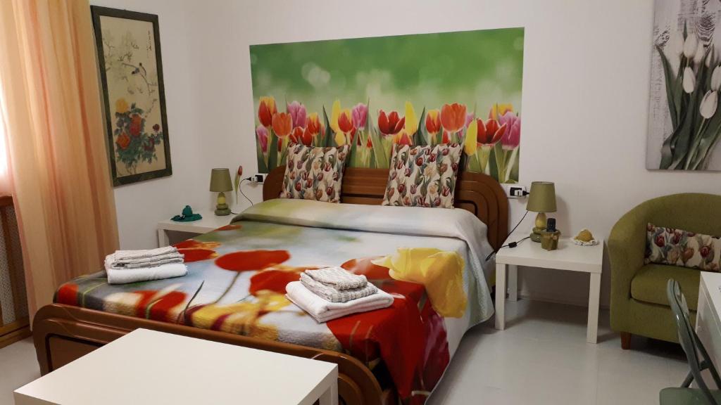 フォッローニカにあるAffittacamere Il Conteのベッドルーム(ベッド1台付)とチューリップの絵画