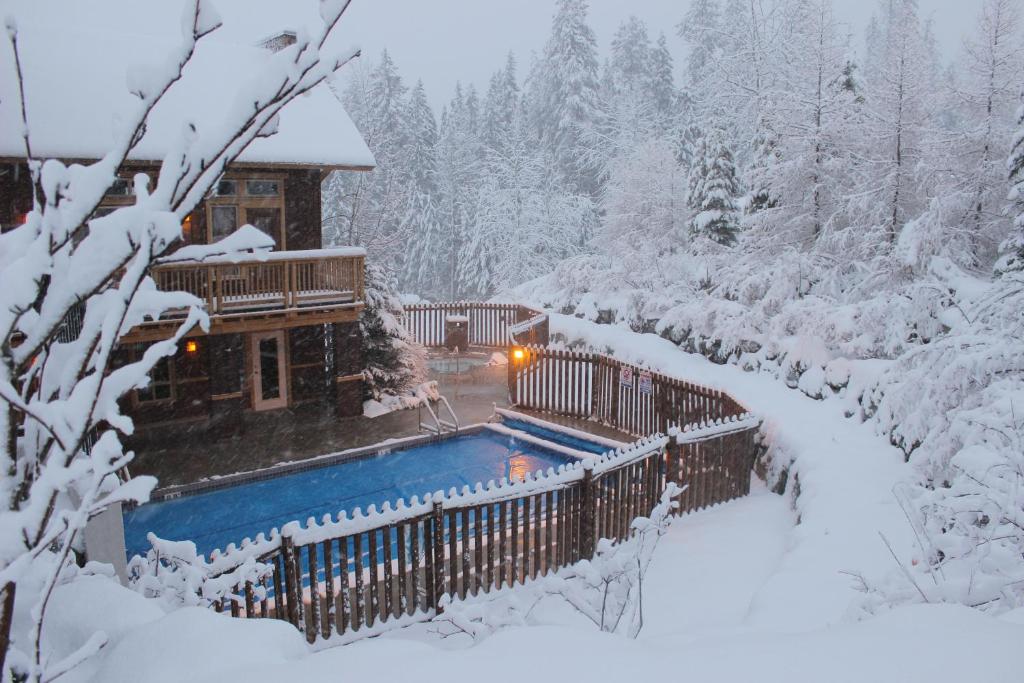 a house in the snow with a swimming pool at Timberline Lodges by Fernie Lodging Co in Fernie
