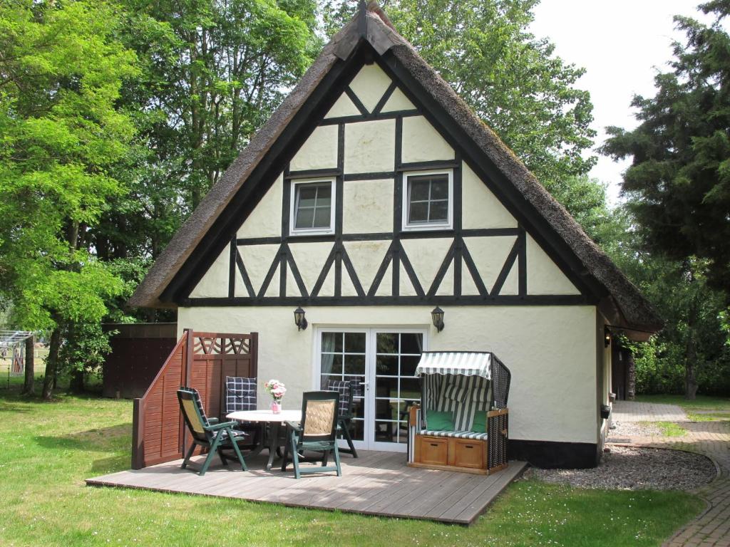een klein huis met een tafel en stoelen op een terras bij Holiday Home Hühnerhaus by Interhome in Nonnevitz