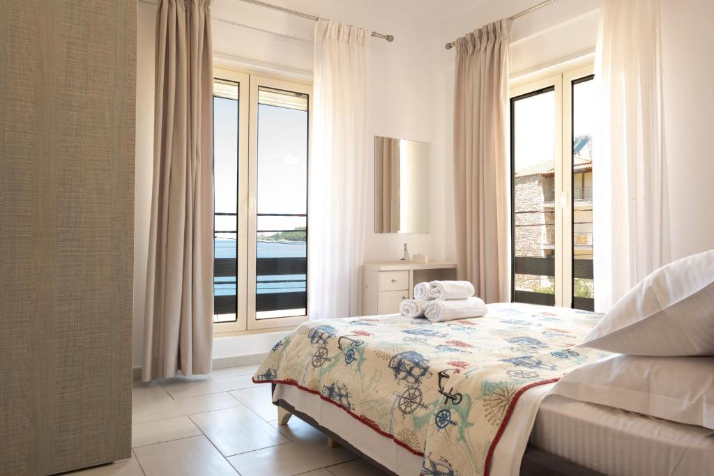 1 dormitorio con 1 cama y ventanas grandes en Sea Apartments Himare, en Himare