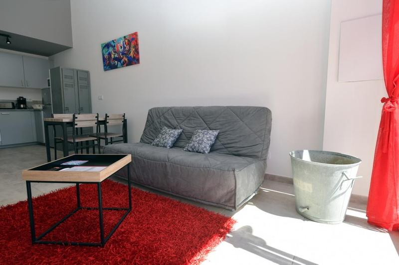 a living room with a couch and a table at Sous Les Pins gîtes et chambres d'hôtes in La Londe-les-Maures