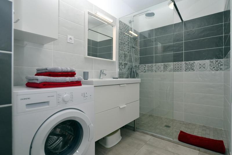 a white washing machine in a bathroom with a sink at Sous Les Pins gîtes et chambres d'hôtes in La Londe-les-Maures