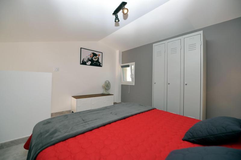 a bedroom with a bed with a red blanket at Sous Les Pins gîtes et chambres d'hôtes in La Londe-les-Maures
