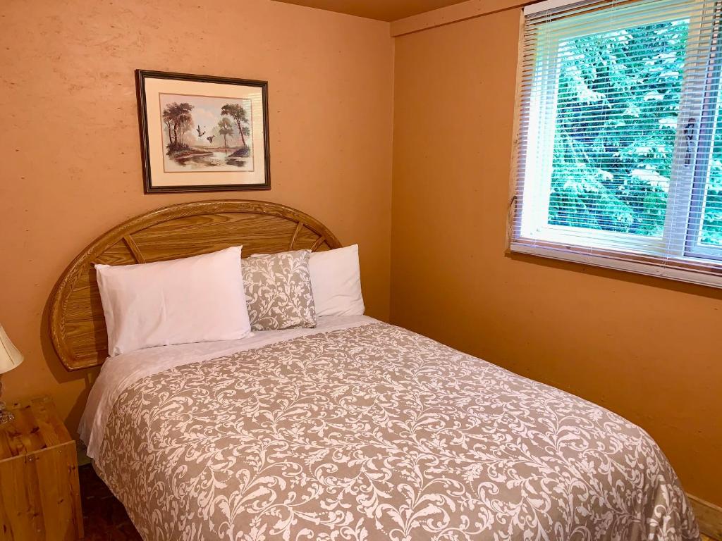 a bedroom with a bed and a window at Schott's Lake Conference & Resort in Sundre