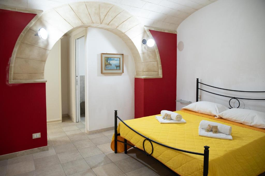 um quarto com uma cama amarela e paredes vermelhas em Fardella 250 em Trapani