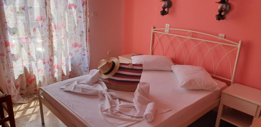 Ilios Apartments في بوروس: غرفة نوم مع سرير مع قبعة عليه