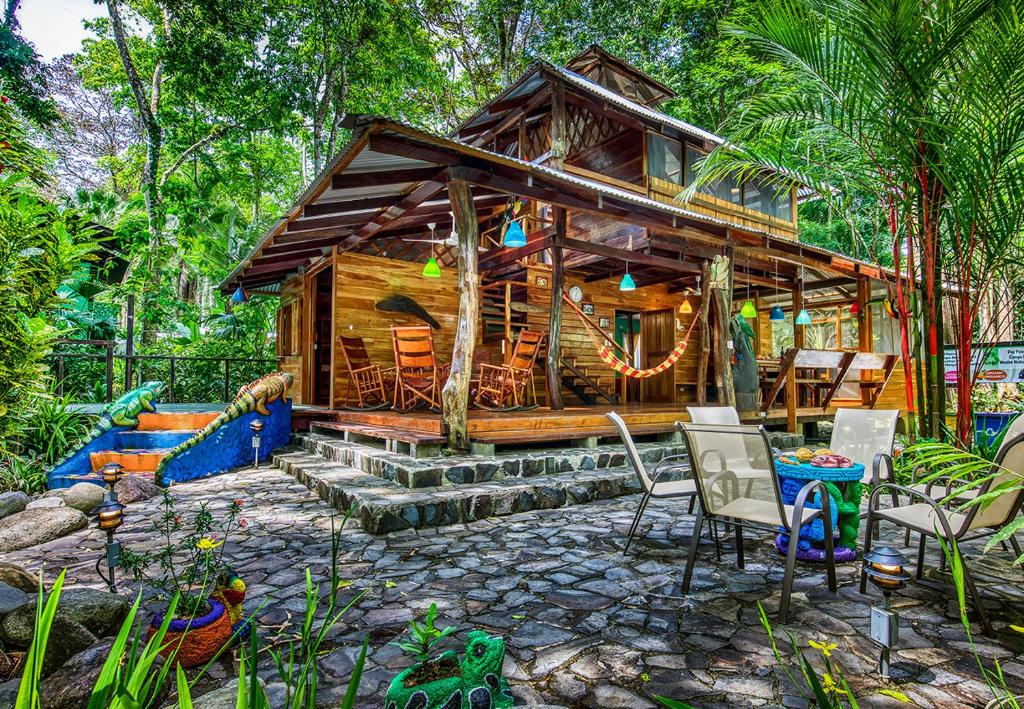 una cabaña en el bosque con sillas y mesa en Congo Bongo EcoVillage Costa Rica, en Puerto Viejo