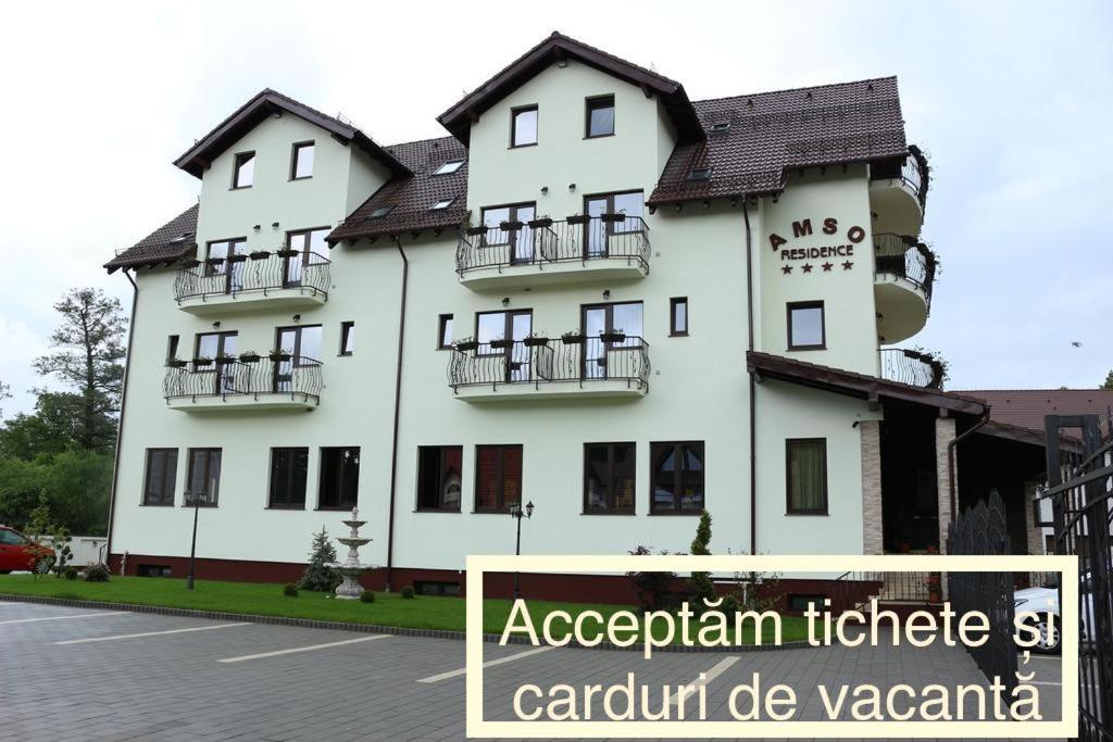 a large white building with a sign in front of it at Amso Residence in Sibiu