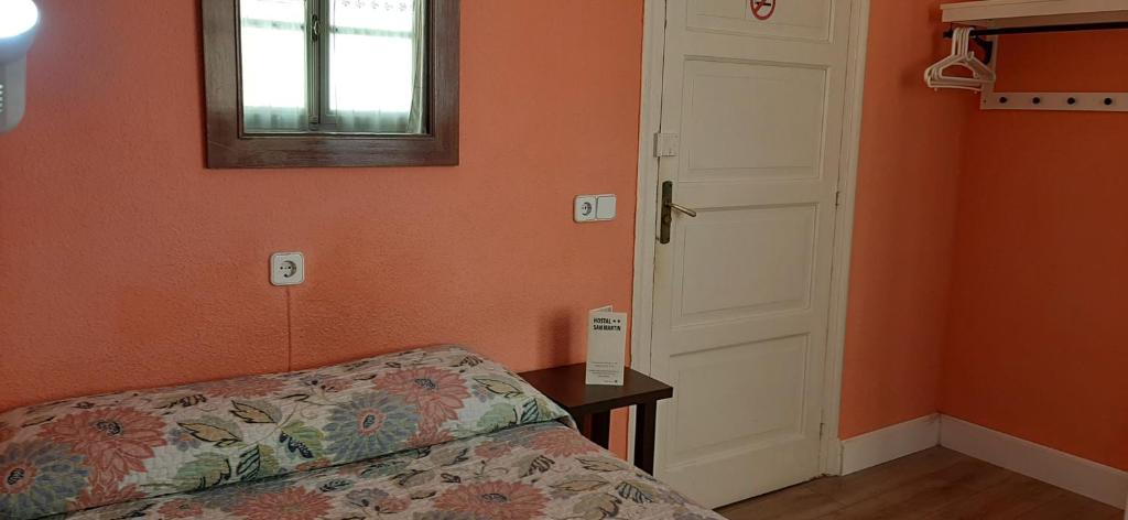 A bed or beds in a room at Hostal San Martin