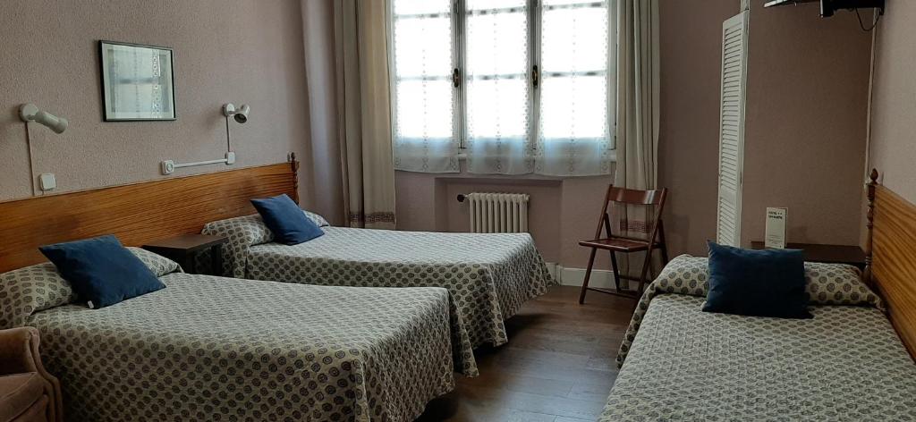 A bed or beds in a room at Hostal San Martin