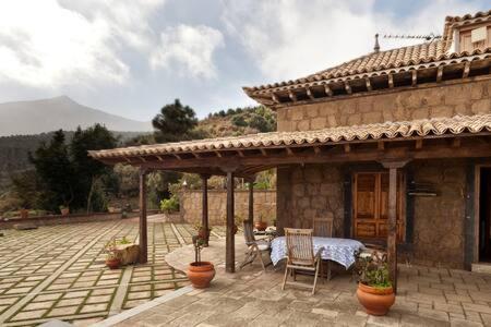 a patio of a house with a table and chairs at Villa Rural Faldas del Teide in Icod de los Vinos