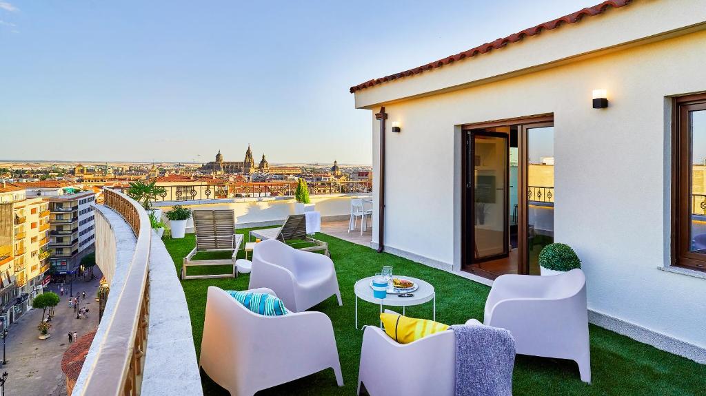 een balkon met stoelen en een tafel en uitzicht bij VUT San Marcos in Salamanca