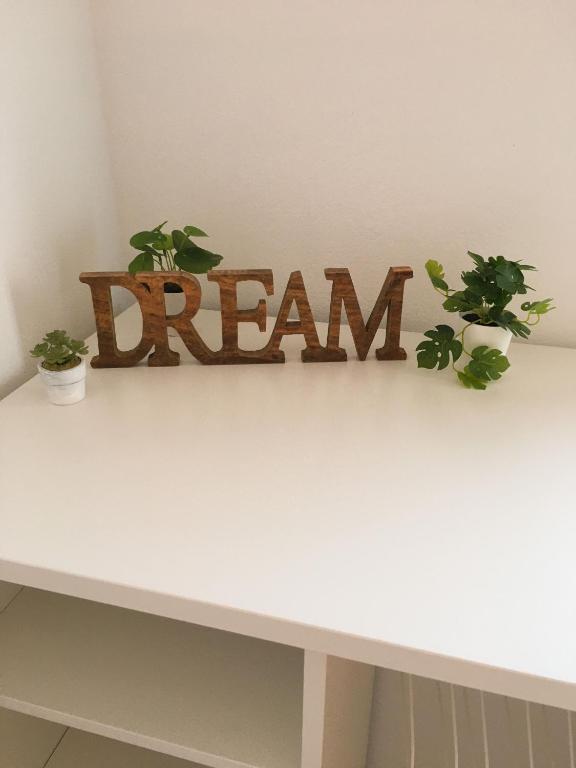a white table with the word dream written on it at Carrapateira Lodge in Carrapateira