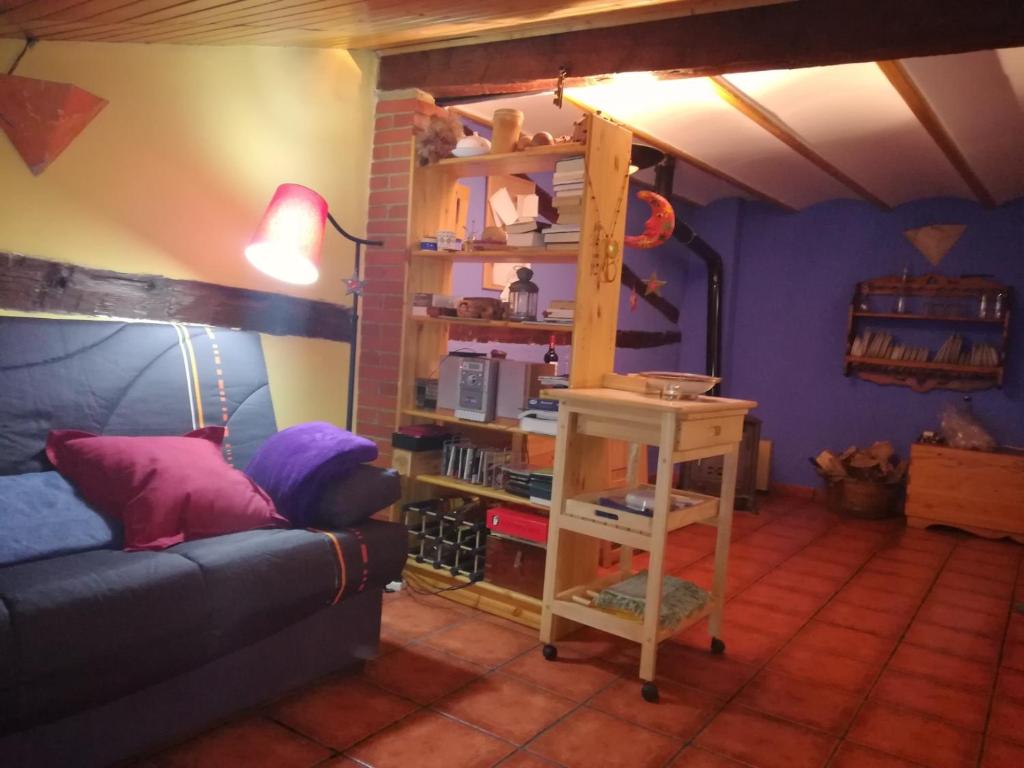 ein Wohnzimmer mit einer Couch und einem Bücherregal in der Unterkunft Casa Valentina y La buhardilla in Salvacañete