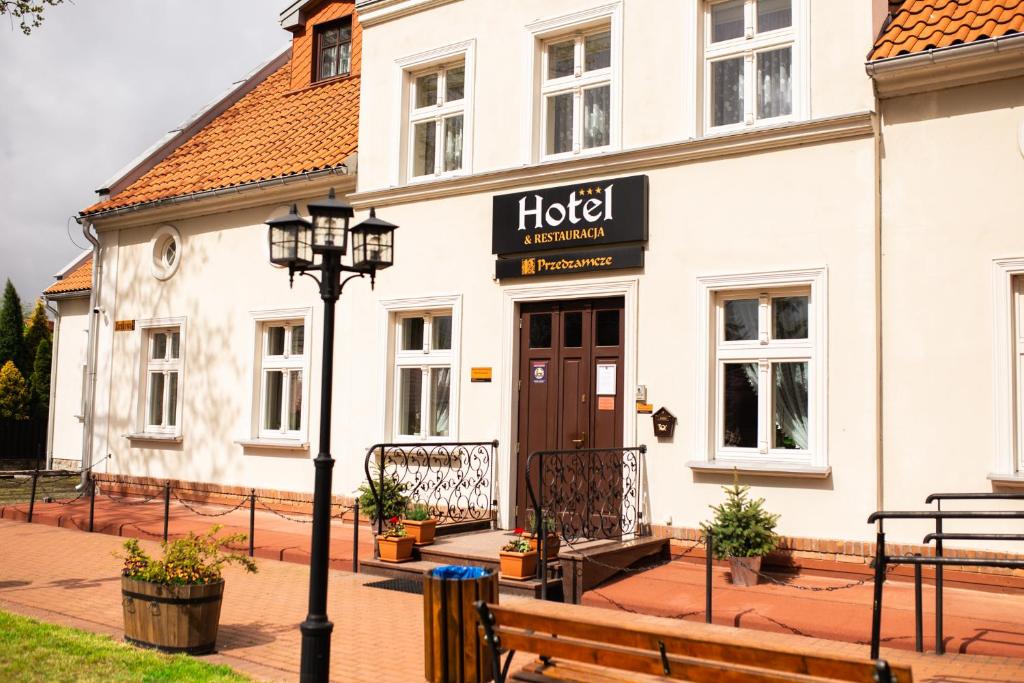 a hotel with a street light in front of a building at Hotel Przedzamcze in Działdowo