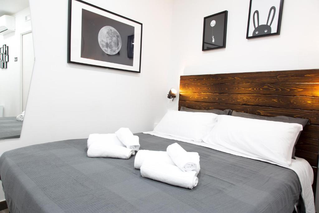 una camera da letto con un letto con cuscini bianchi di [Via Dei Tribunali–Duomo] Casina in Centro Storico a Napoli