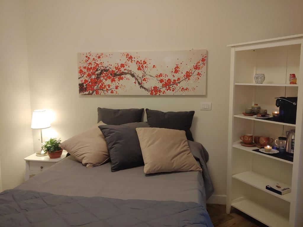 a bed in a bedroom with a painting on the wall at TINY ROOM in Sassari