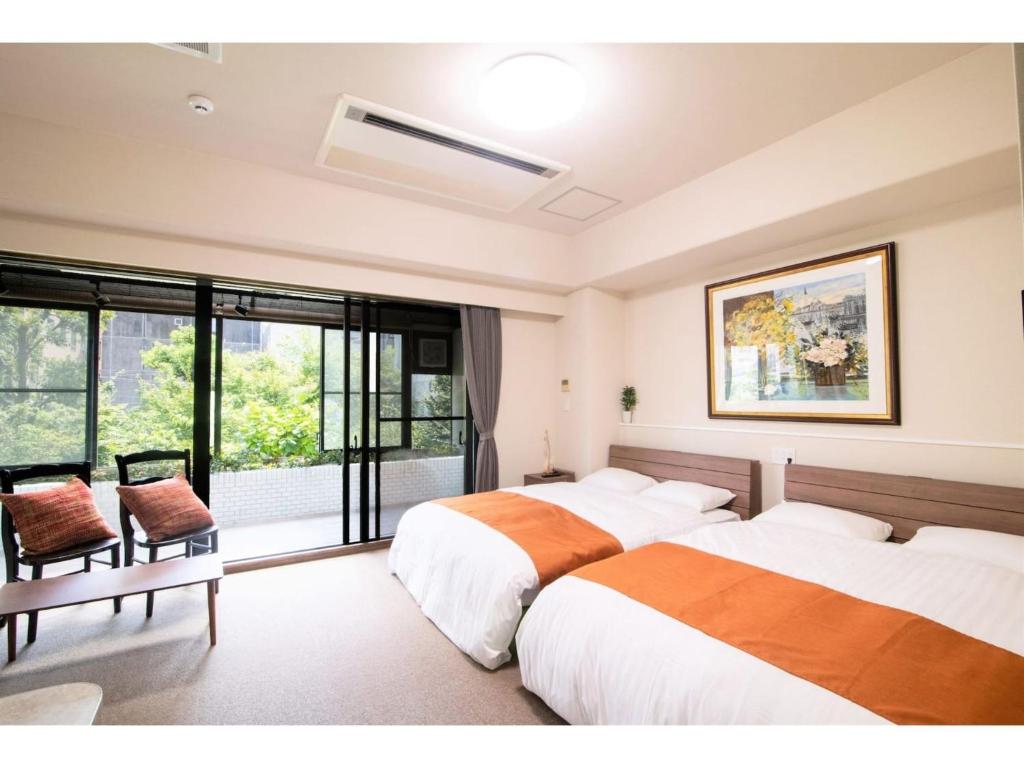 two beds in a room with a window at Arbor house - Vacation STAY 86731 in Kagoshima