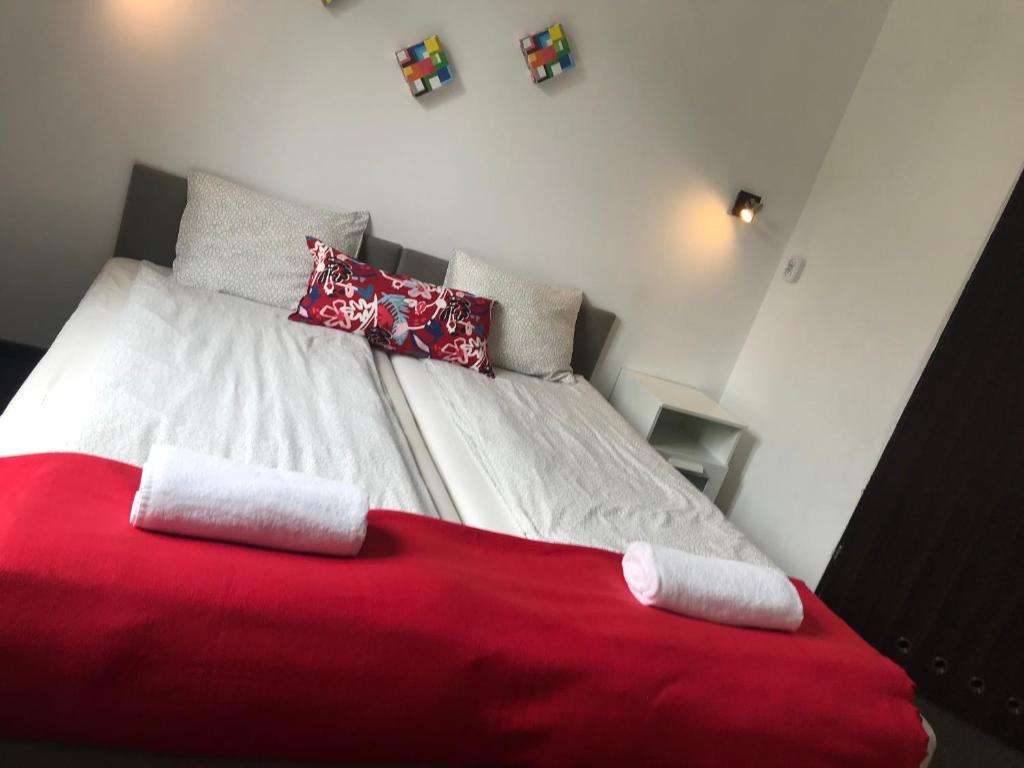 una camera con letto rosso e bianco con cuscini di Szekla a Stronie Śląskie