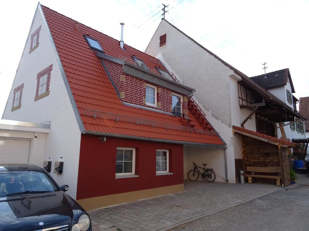 a white and red house with a red roof at Pensionszimmer Ziaglhidde in Kiebingen