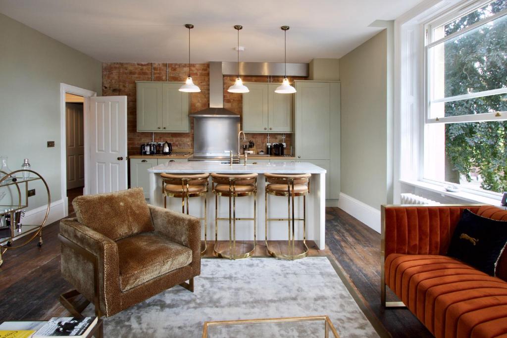 a kitchen with a counter and a bar with chairs at Old Bank Apartments in Stamford