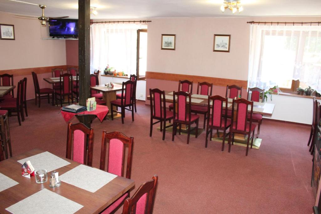 a dining room with tables and chairs in a restaurant at Penzion Avena in Stříbro