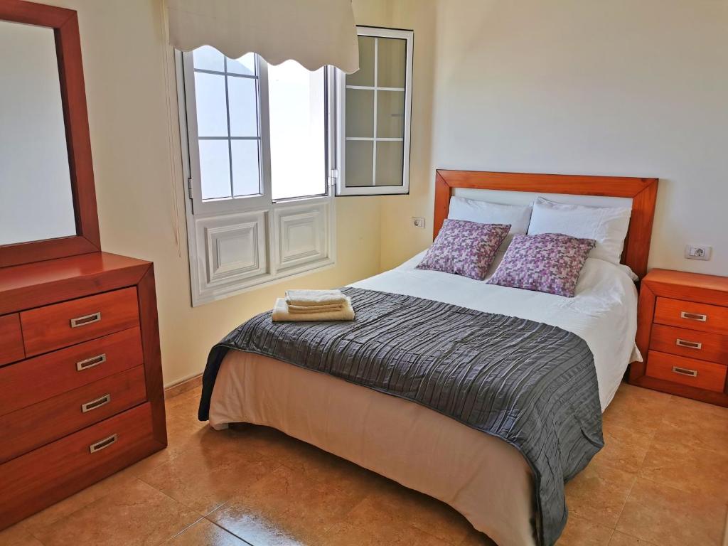 - une chambre avec un lit avec deux oreillers et une fenêtre dans l'établissement Apartamentos Brito, à Orzola
