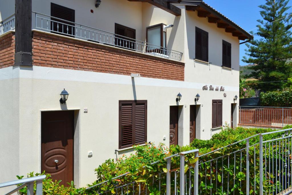 een groot wit huis met een hek ervoor bij Le case del Carmine con giardino e parcheggio a Tropea in Tropea