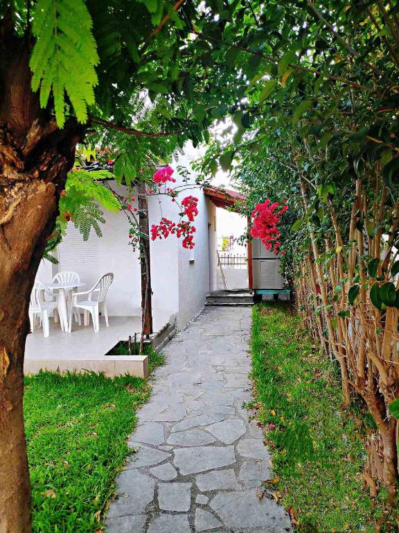 a stone walkway next to a white building with flowers at Maisonette with Garden& Parking Polichrono in Polychrono