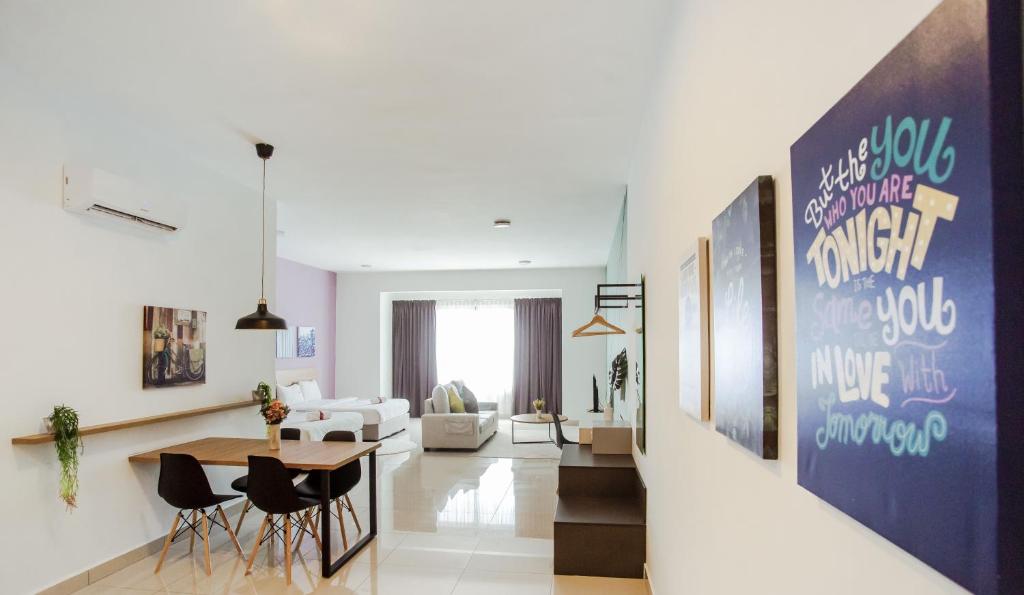 uma sala de estar com uma mesa e cadeiras em Da Men Sunway Subang By ODY Suites em Subang Jaya