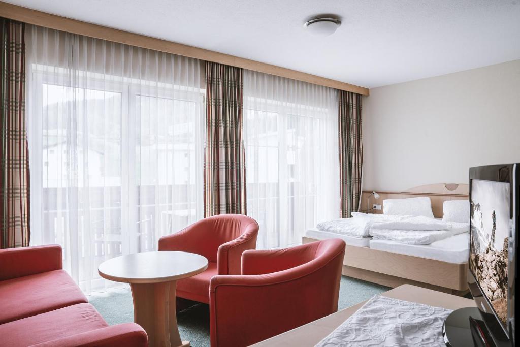 pokój hotelowy z łóżkiem, stołem i krzesłami w obiekcie Landhaus Martinus w Solden