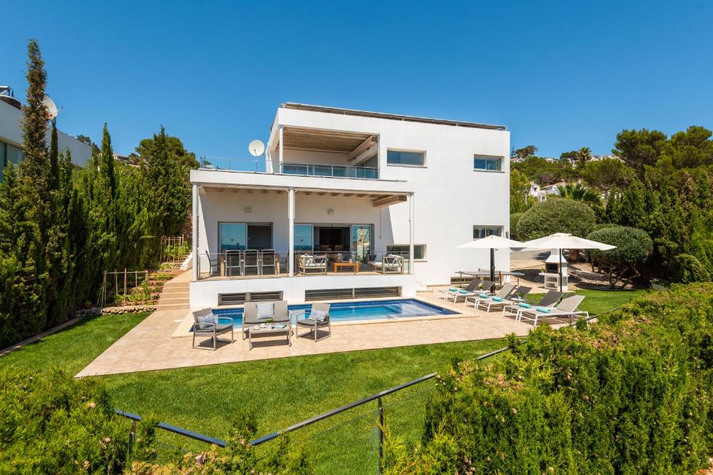 a villa with a swimming pool and a house at Villa Orquidea in Son Bou
