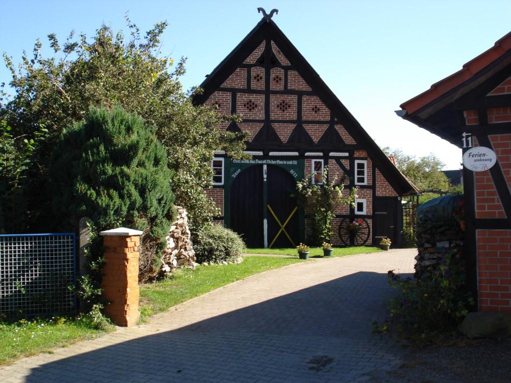 une maison avec une porte noire et une allée. dans l'établissement de lüt Ferienhof Jameln, à Jameln