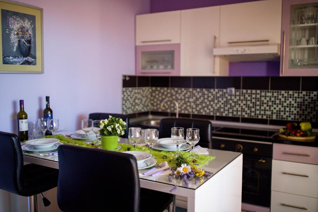 a kitchen with a table with plates and glasses on it at Apartments Vinka in Sveti Filip i Jakov