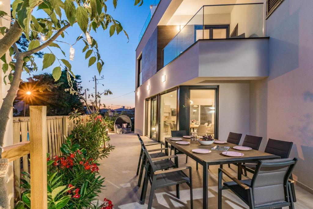 a dining table in the backyard of a house at Villa Elena Deluxe mit Whirlpool und POOL am MEER in Fažana