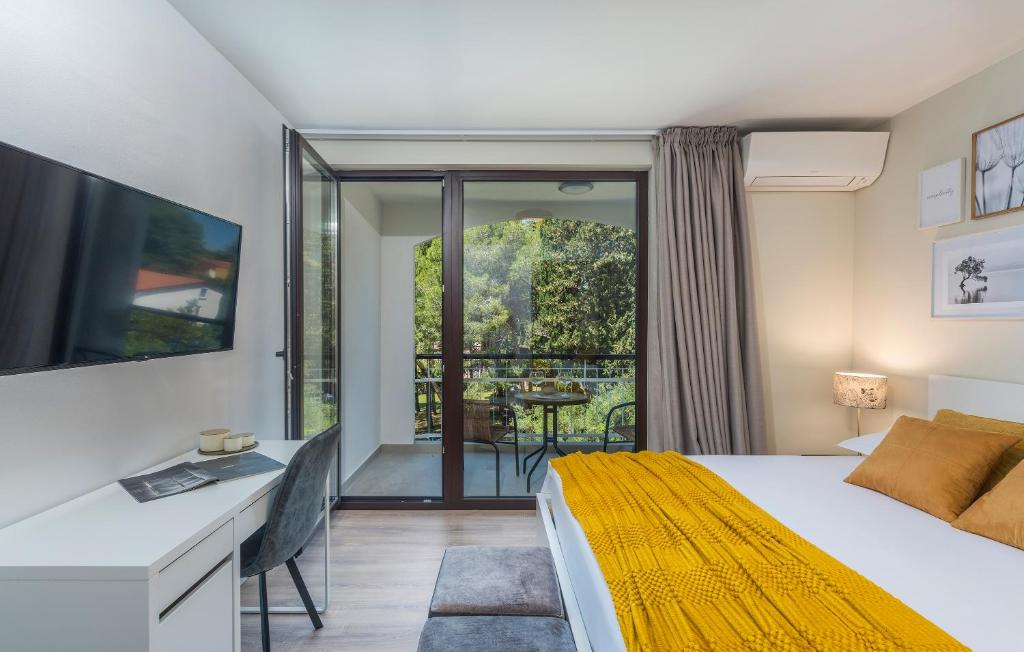 1 dormitorio con cama, escritorio y balcón en JUST RENOVATED stylish 2 bedrooms apartment only a few steps from the beach! en Novigrad Istria
