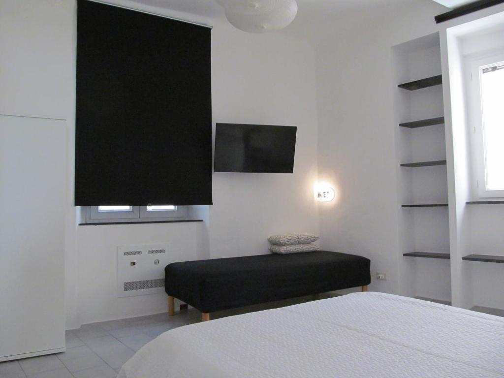 um quarto com uma cama e uma televisão de ecrã plano em Old Town Guest House em Gênova