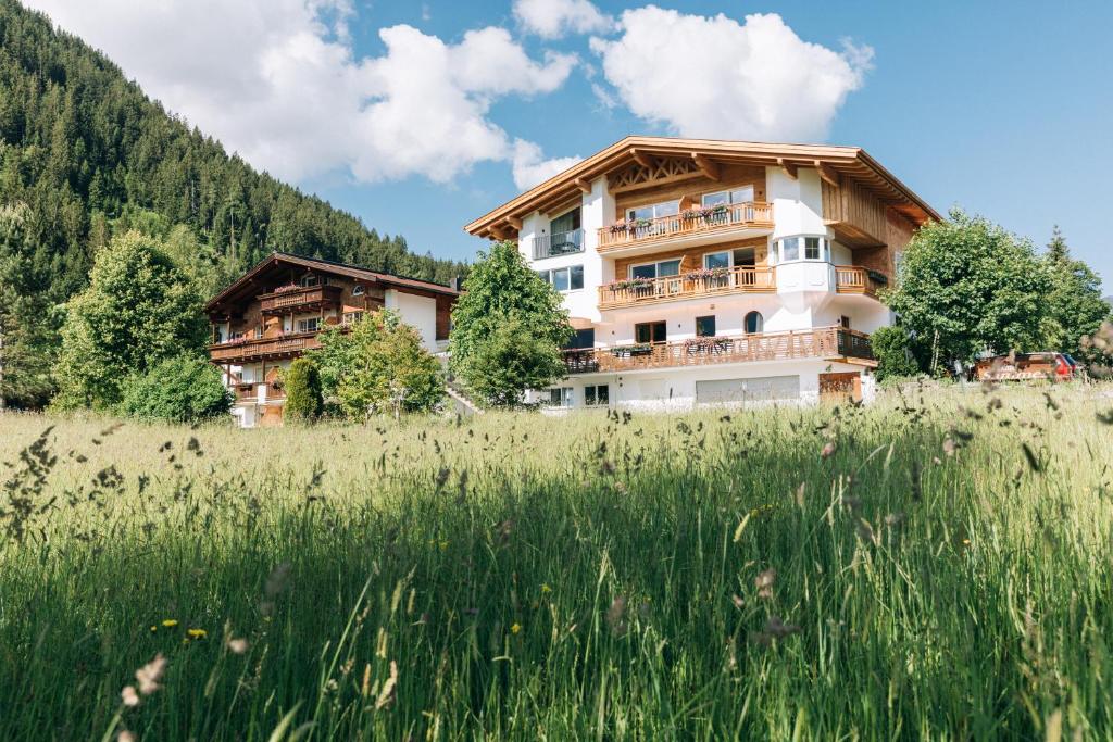 a building on a hill with a field of grass at Landhaus Sammer in Tannheim