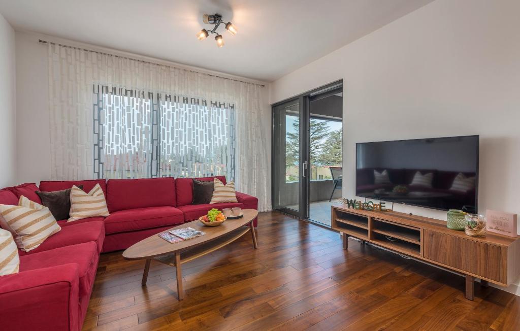 uma sala de estar com um sofá vermelho e uma televisão de ecrã plano em SPADA Apartment 3 bedrooms near the beach! em Porec