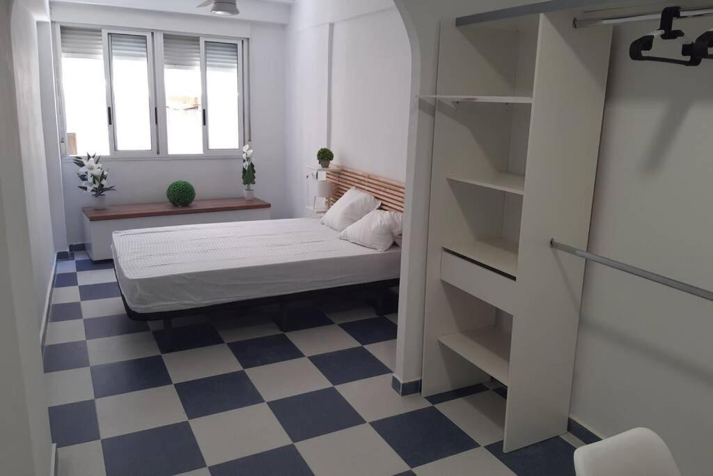 um quarto com uma cama e um piso em xadrez em Apartamento junto a la Catedral 2 dormitorios em Almeria