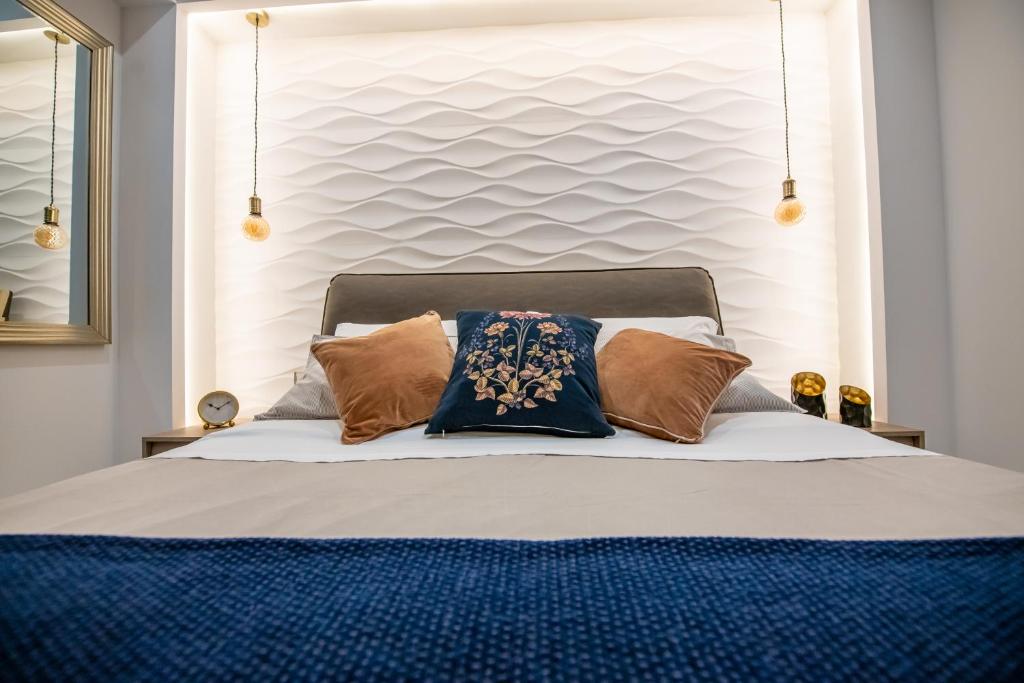 um quarto com uma cama com almofadas em Artist Terrace Apartments em Mellieha