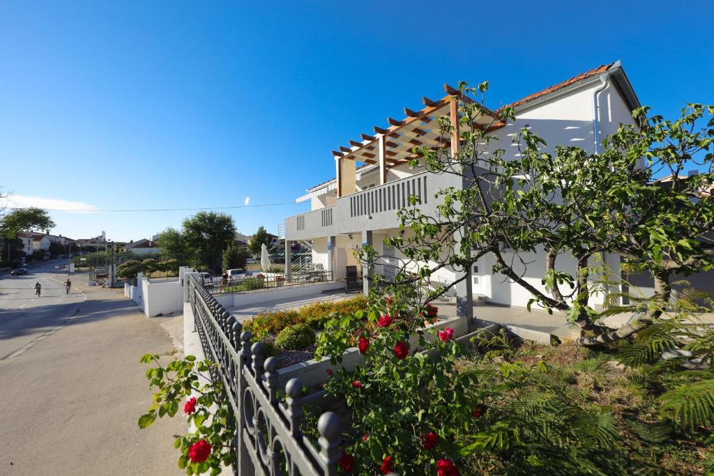 een huis met bloemen voor een hek bij Pavle's Apartment in Zadar