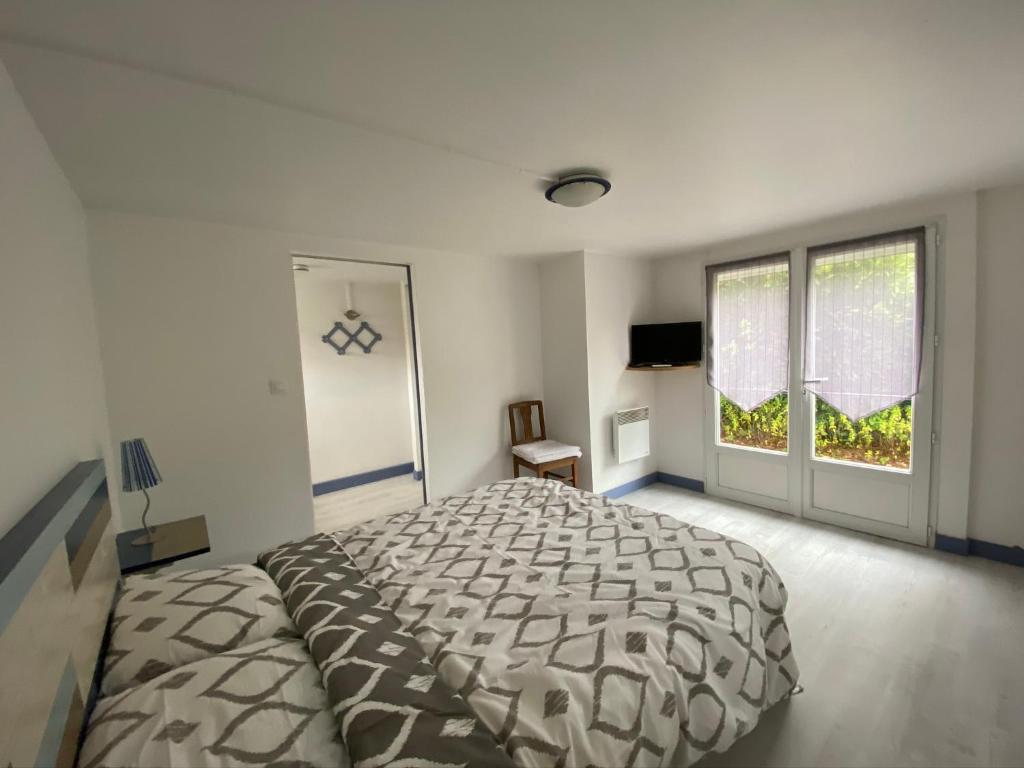 a bedroom with a large bed and a large window at CENTRE CHATELAILLON GRAND T2** AVEC COUR 100mPLAGE in Châtelaillon-Plage