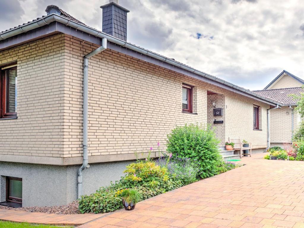 a white brick house with a brick driveway at Sunny flat in Bad Driburg with garden in Bad Driburg