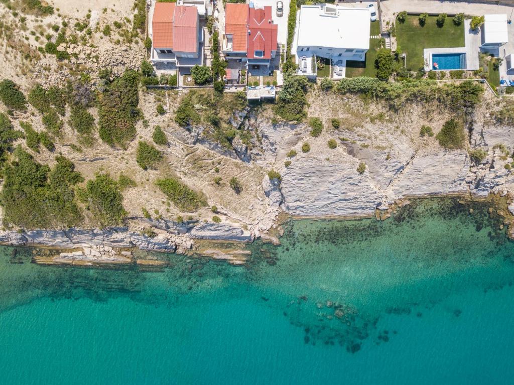 una vista aerea di una spiaggia con acqua blu di A White Cliffside Studio a Pag