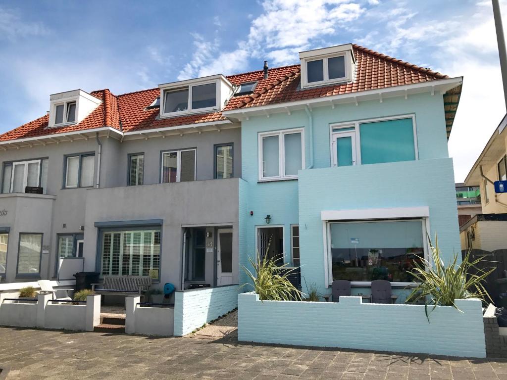 una casa azul con techo rojo en Odyssee, en Zandvoort