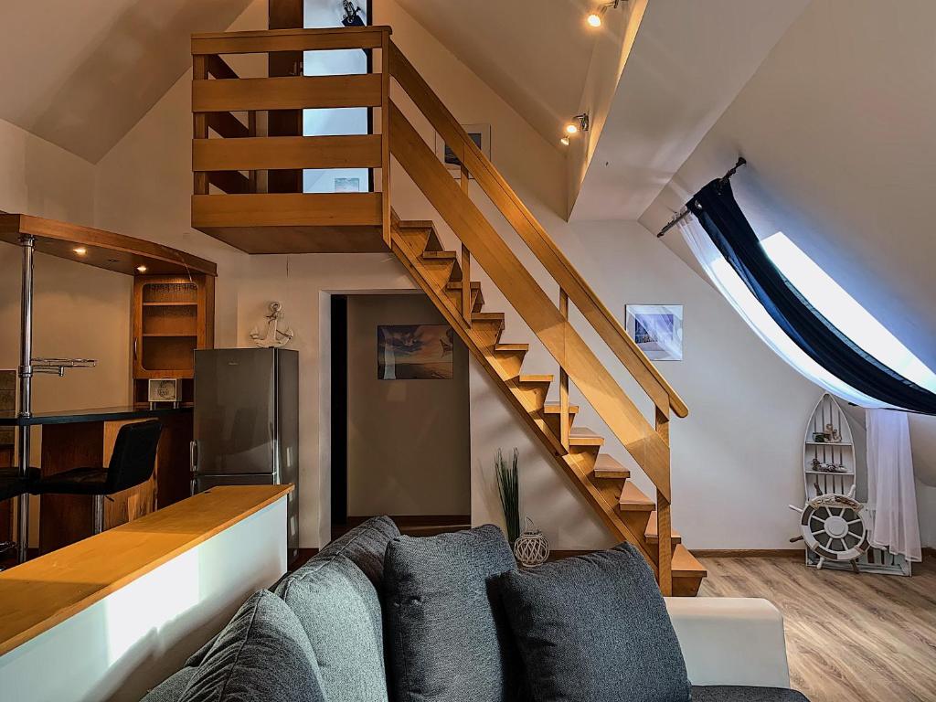 a living room with a couch and a staircase at Apartament Ustronie Leśne in Międzyzdroje